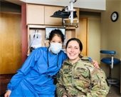 Dr. Fung, owner of Designing Smiles with woman in U.S. Army Uniform in dentist office. 