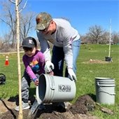 A child learns to plant a tree.