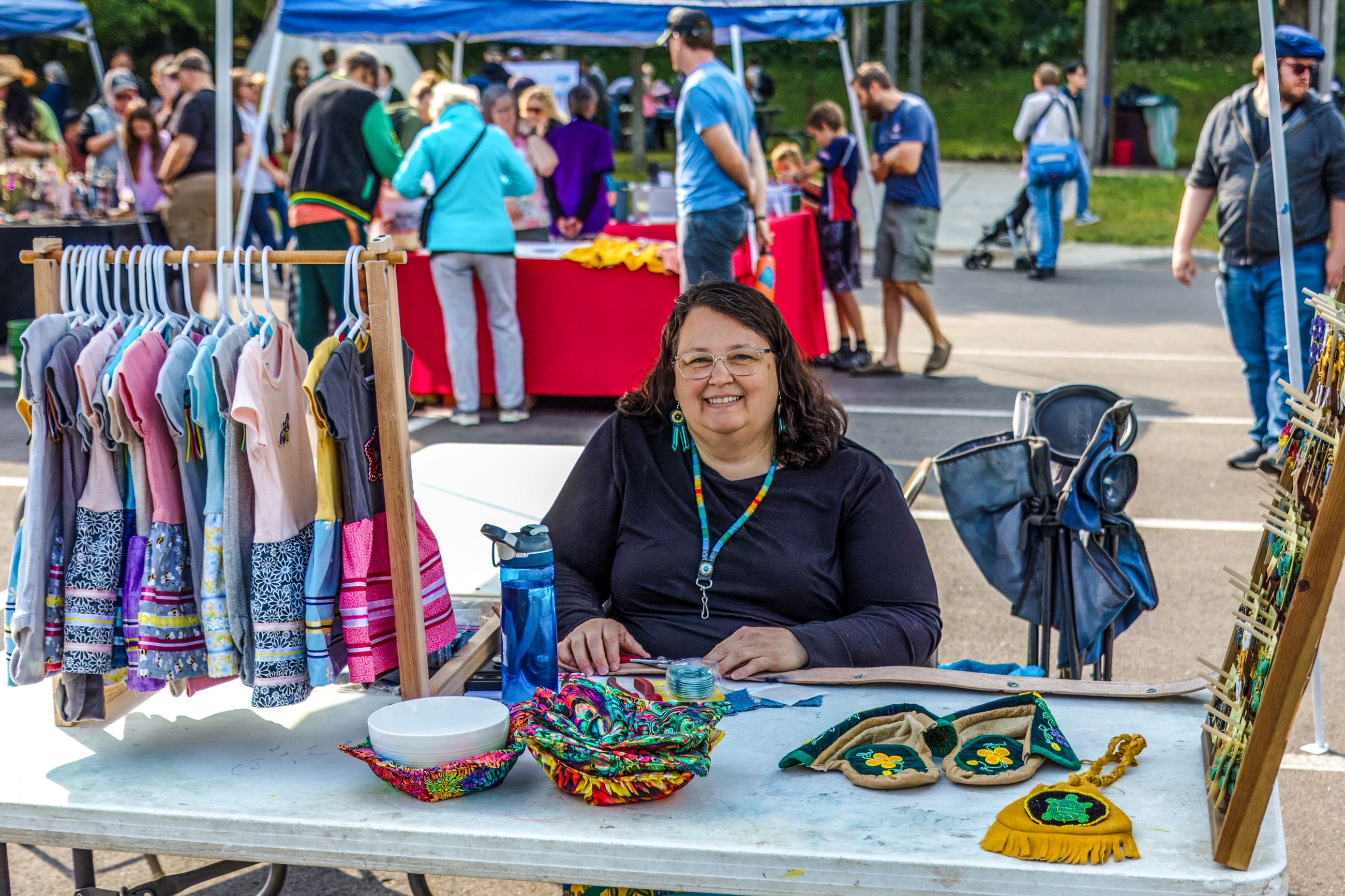Woman sitting at table with beaded and sewn garments