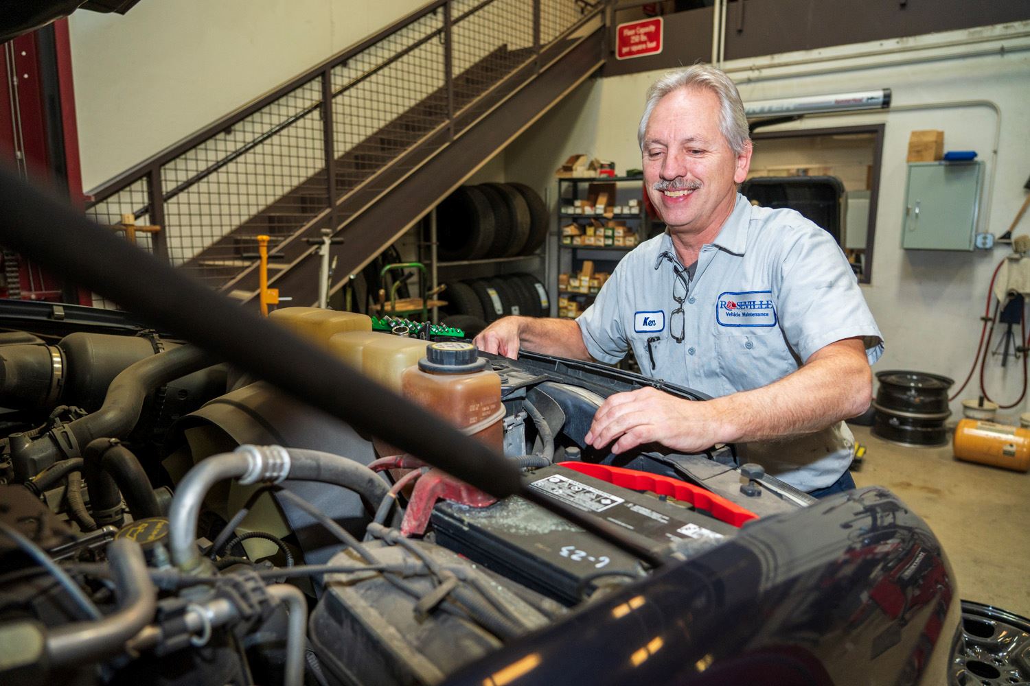 Roseville mechanic Ken Hopkins smiles while working on a work truck.