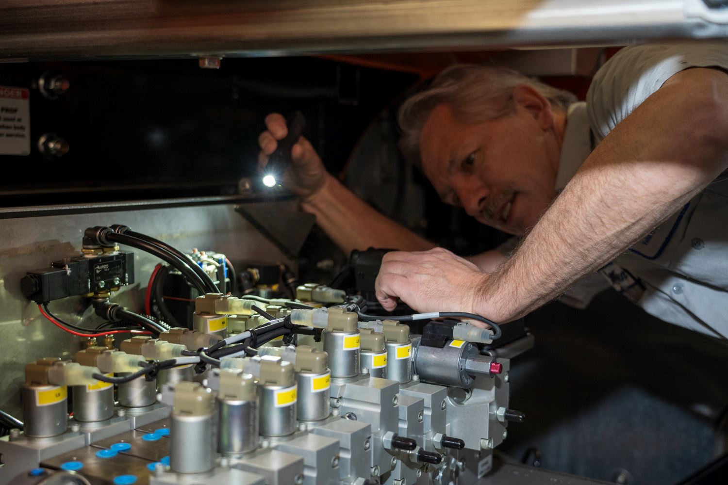 Roseville Mechanic Ken Hopkins works on a snow plow.
