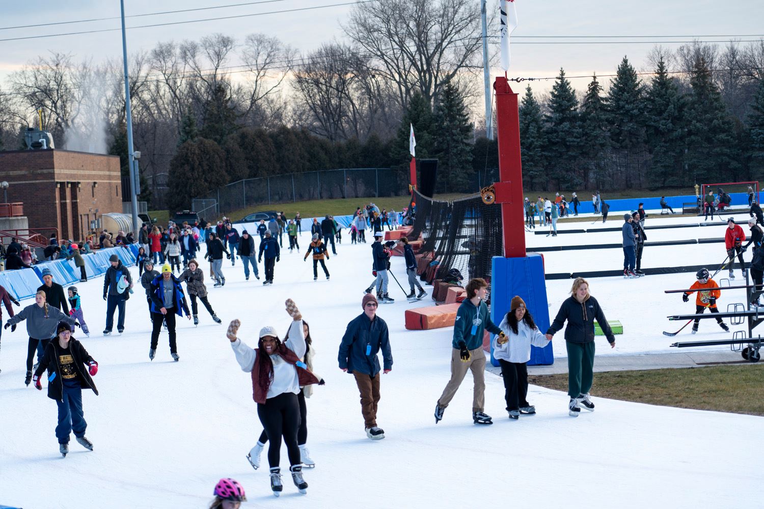A large group of people skate at the John Rose MN OVAL.