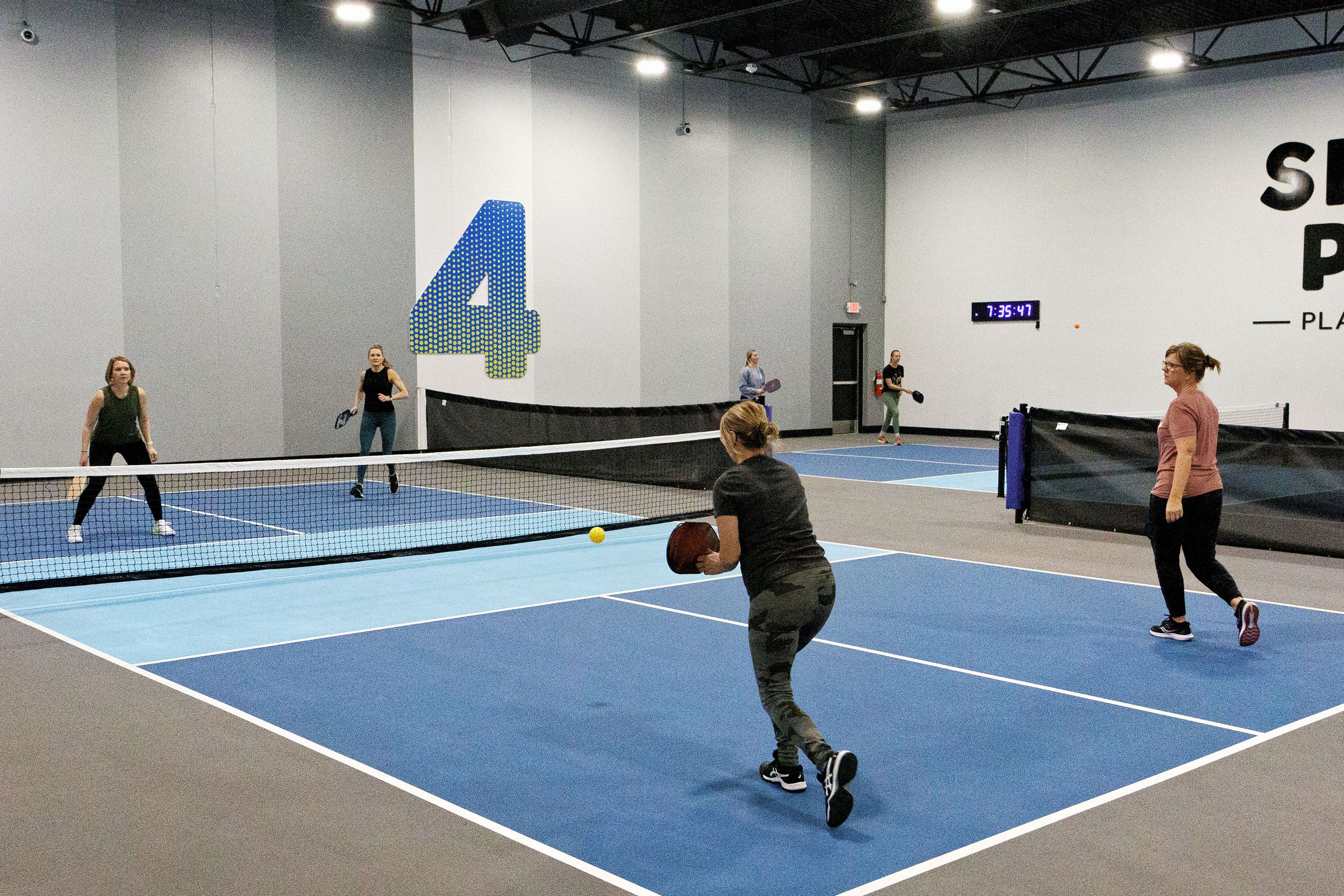 Women play pickleball at Smash Park.