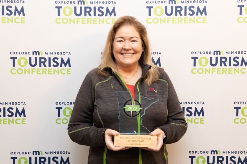 Julie Wearn smiles with an award from Explore Minnesota.